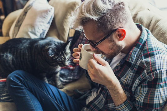 Man drinking coffee with his cat